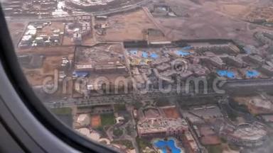 从热带度假胜地的飞机窗口可以看到埃及沙漠中的异国酒店和游泳池